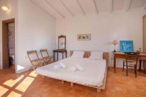 a bedroom with a bed and a desk and chairs at Roxanne's Olive Grove House in Kranidi
