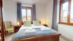 La maison Blanche - Issenheim في Issenheim: غرفة نوم عليها سرير وفوط