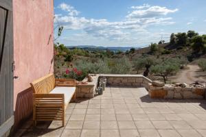 a patio with two chairs and a bench on a building at Roxanne's Olive Grove House in Kranidi