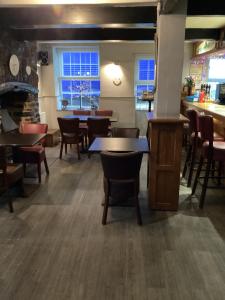 a restaurant with tables and chairs and a bar at The Coach and Horses in Parkham