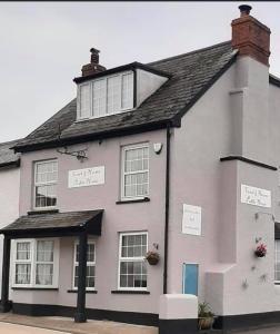 a white house with signs on the side of it at The Coach and Horses in Parkham