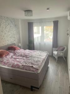 een slaapkamer met een bed, een stoel en een raam bij Premium Home 23 in Wenen