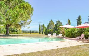 a swimming pool with two lawn chairs and an umbrella at Cozy Home In Montaut With Outdoor Swimming Pool in Montaut