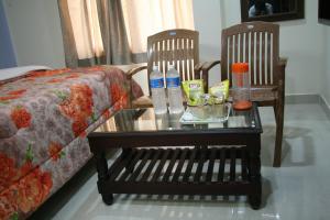 einen Couchtisch mit zwei Stühlen und einem Sofa in der Unterkunft KVP Inn in Tirupati