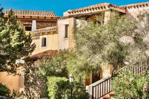 uma casa grande com árvores em frente em Residence con piscina a Liscia di Vacca, 350 mt dal mare, 3 km da Porto Cervo em Liscia di Vacca