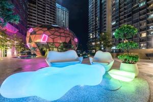 a group of chairs and a sphere in a city at night at The Arte Plus KLCC BY Tenang Homes in Kuala Lumpur