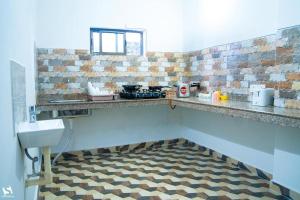 Il comprend une cuisine dotée d'un comptoir avec évier et de carrelage. dans l'établissement Dibrugarh Tea Residency, à Dibrugarh