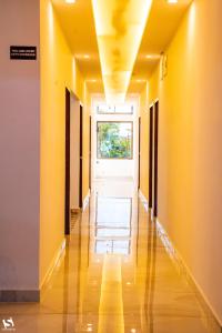 un couloir vide avec des murs jaunes et une fenêtre dans l'établissement Dibrugarh Tea Residency, à Dibrugarh