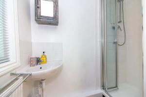 a bathroom with a sink and a shower at Bradstone Garden Retreat in Folkestone