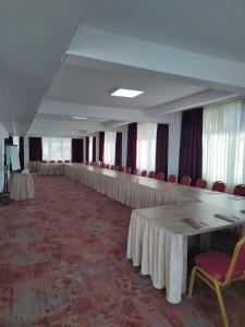 Großes Zimmer mit Tischen und roten Stühlen in der Unterkunft Austrian Palace Hotel in Skopje