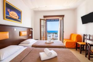 een hotelkamer met 2 bedden en een balkon bij Irini Hotel in Afiartis