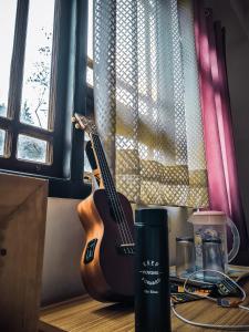 Pemayangtse的住宿－Hotel Himsagar，坐在窗边桌子上的吉他