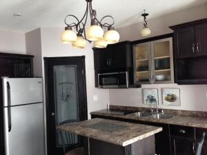 a kitchen with black cabinets and a white refrigerator at Chaparral Inn in Arcola