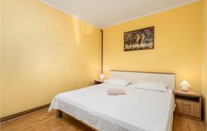 een slaapkamer met een wit bed en een foto aan de muur bij Stunning Apartment In Lovran With Kitchen in Lovran