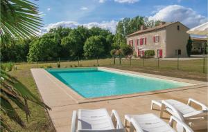 a swimming pool with white chairs and a house at Stunning Home In St Maixent De Beugné in Saint-Maixent-de-Beugné