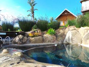 a pool of water with rocks and a house at Addo Dung Beetle Guest Farm in Addo +93 photos