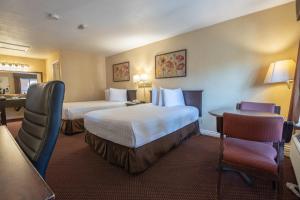 a hotel room with two beds and a desk at Hospitality Inn in San Bernardino