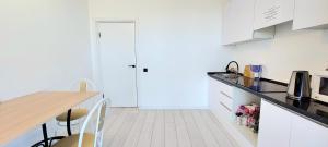 een keuken met witte kasten en een tafel met stoelen bij Аэропорт 10 минут in Astana +4 foto's