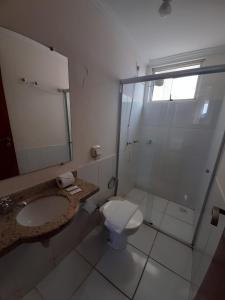 a bathroom with a shower and a toilet and a sink at Hotel Toulon Caldas Novas in Caldas Novas