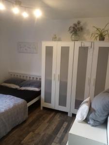 sypialnia z 2 łóżkami i białą szafką w obiekcie Albany Rooms w mieście Bexley