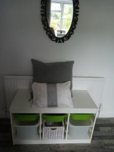 een witte tafel met 2 kussens en een spiegel bij Albany Rooms in Bexley