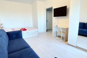 een woonkamer met een blauwe bank en een bed bij Аэропорт 10 минут in Astana