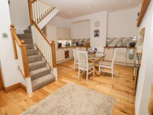 a kitchen and dining room with stairs and a table at On the Straits in Menai Bridge