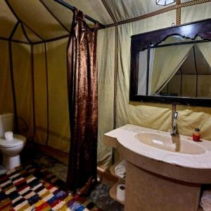 a bathroom with a sink and a toilet in a tent at Blue Sky Luxury Camp in Merzouga