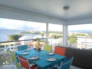 a dining room with a blue table and colorful chairs at Appartement Ti Bato in Les Trois-Îlets