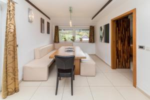 cocina con mesa, silla y sofá en Apartments Mrak en Bohinj