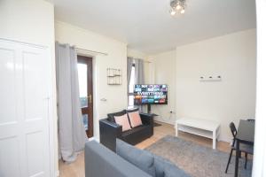 a living room with a couch and a tv at Lovely 4 bedroom apartment close to the city walking distance from the rivere view in London