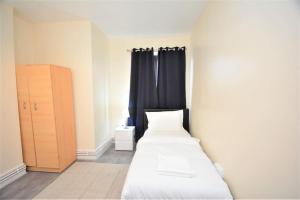 a bedroom with two beds and a window with curtains at Lovely 4 bedroom apartment close to the city walking distance from the rivere view in London