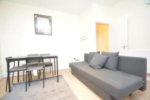a living room with a couch and a table at Lovely 4 bedroom apartment close to the city walking distance from the rivere view in London