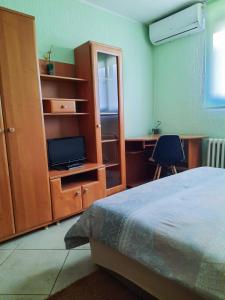 een slaapkamer met een bed en een kast met een televisie bij S&Z Hostel in Banja Luka