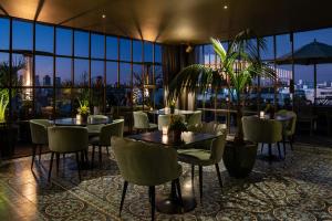 um restaurante com mesas e cadeiras e vista para a cidade em Hotel Montevideo - Leading Hotels of the World em Montevidéu