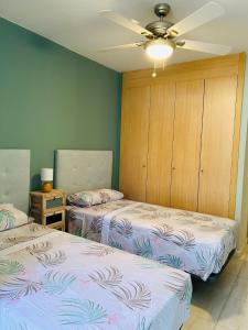 a bedroom with two beds and a ceiling fan at La Maison Amarilla Golf in San Miguel de Abona