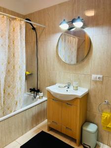 a bathroom with a sink and a tub and a mirror at La Maison Amarilla Golf in San Miguel de Abona