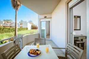 a table with a plate of food on a balcony at Gelina Apartments in Platanias