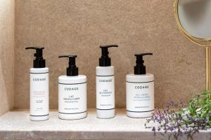 a group of four bottles of grooming products on a shelf at Kimpton Aysla Mallorca by IHG in Santa Ponsa