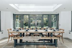 uma grande sala de jantar com uma mesa de madeira e cadeiras em Woodvale - Sleeps 20 em Harpsden