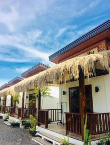 a building with a straw roof and a patio at Alona Vikings Lodge in Panglao Island