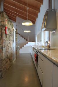 uma cozinha com um balcão e uma parede de pedra em Monte Bandarro Novo, Country House em Cercal do Alentejo
