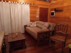 a living room with a couch and a chair at CARELHUE GUAZU 1 in Villa Paranacito