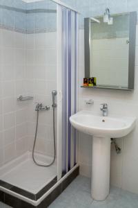 y baño con lavabo y ducha con espejo. en Gelina Apartments, en Plataniás