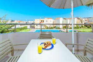 a table with a plate of food and drinks on a balcony at Gelina Apartments in Platanias +40 photos