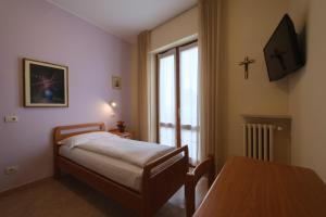 1 dormitorio con cama, mesa y ventana en Casa Vacanza - Casa del Padre Nascimbeni, en Torri del Benaco