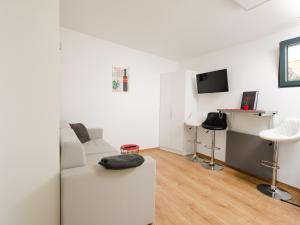 sala de estar con sofá blanco y escritorio en Ipsmiller Appartements, en Schrattenberg