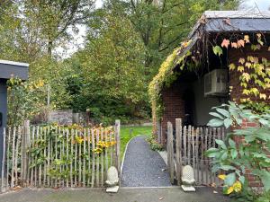 einen Zaun vor einem Haus mit Garten in der Unterkunft Sweetwater Privé Wellness in Oud-Heverlee