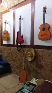 three acoustic guitars are hanging on a wall at Pousada Lira Praieira Paraty in Paraty