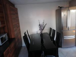 una mesa de comedor con un jarrón de flores. en Large House with 3 Bedrooms house, 5 guests near city/Manu stadiums en Mánchester